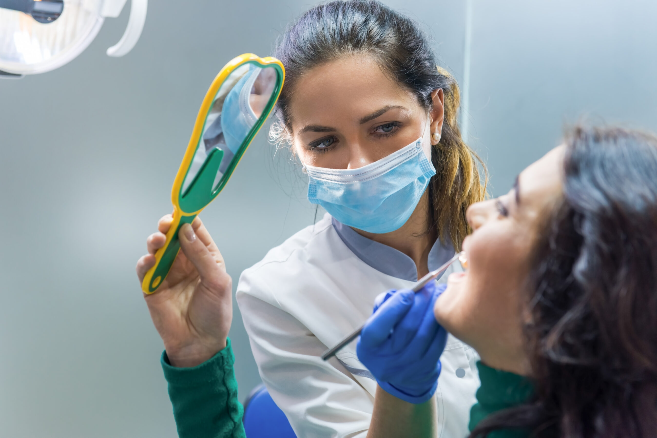 dentist and patient holding mirror.