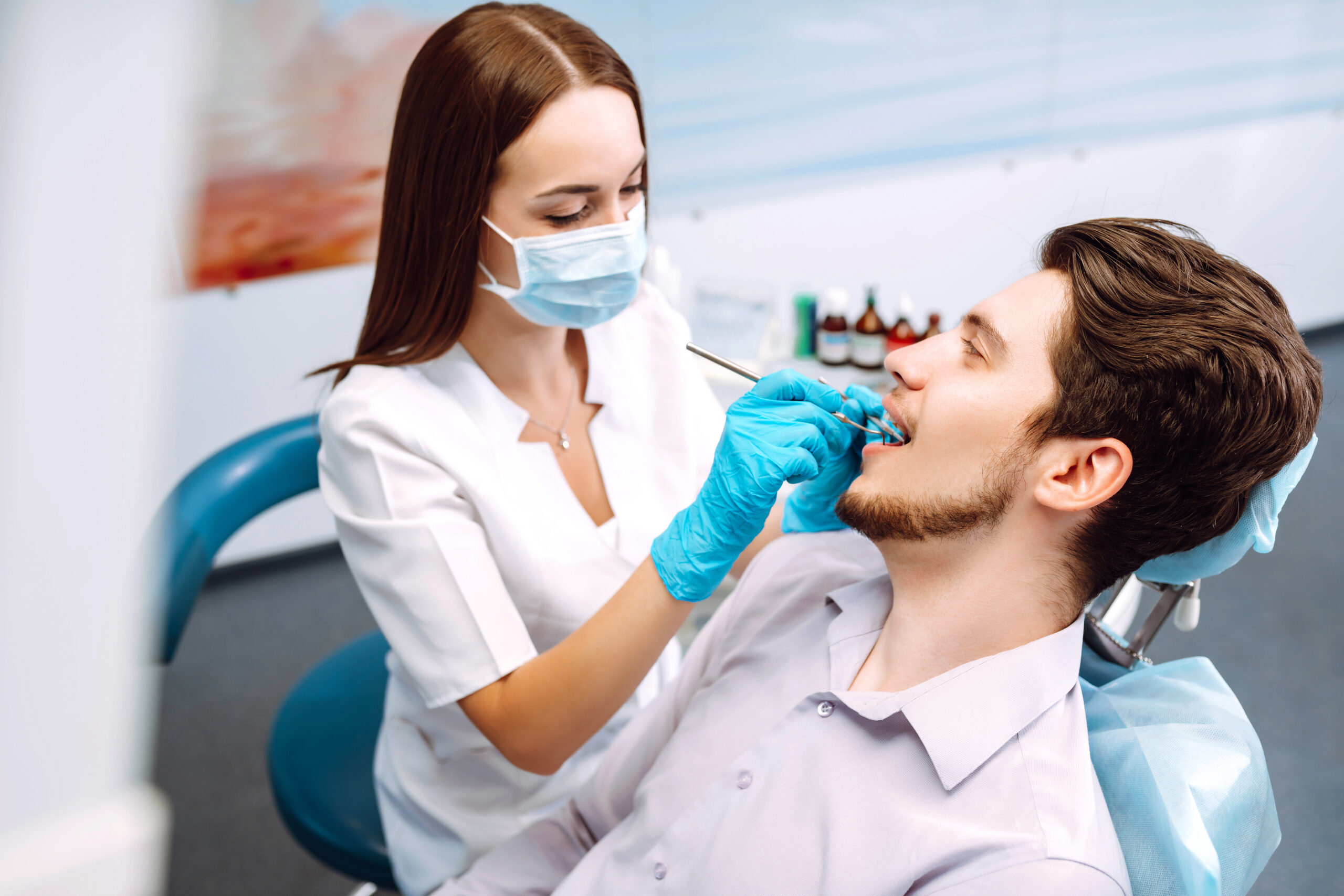 young man at the dentist's chair during a dental procedure. overview of dental caries prevention.